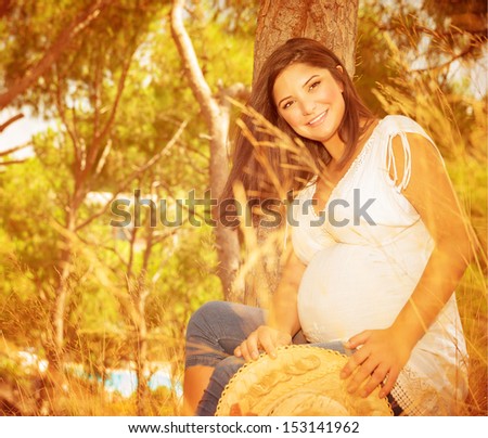 Expectant female on backyard in warm autumnal day, happy maternity, autumn season, awaiting for a baby, new life concept