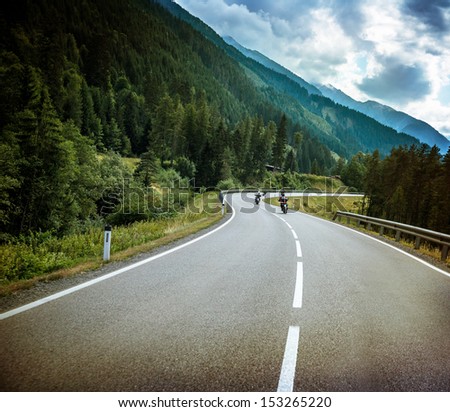 Group of bikers on mountainous road, fresh green forest, Alpine mountain, traveling on motorbike, active sport, speed concept