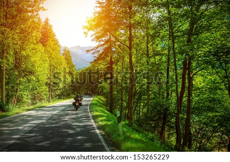 Biker On Mountainous Road In Sunset Light, Motorcyclist On Highway, Drive Motorbike Along Alps, Europe Trip, Beautiful Forest, Active Lifestyle