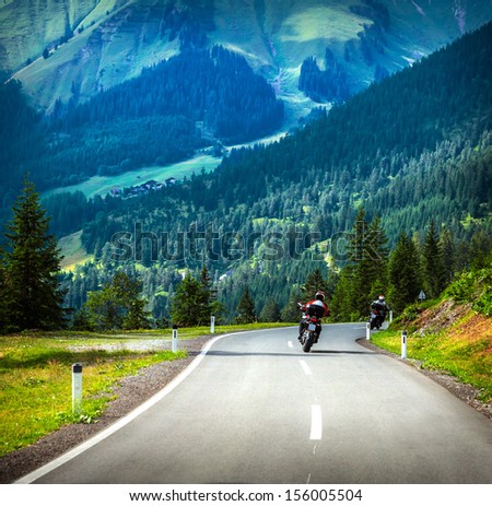 Group of bikers riding in mountains, beautiful mountainous landscape, green forest, leisure time, holiday and vacation concept