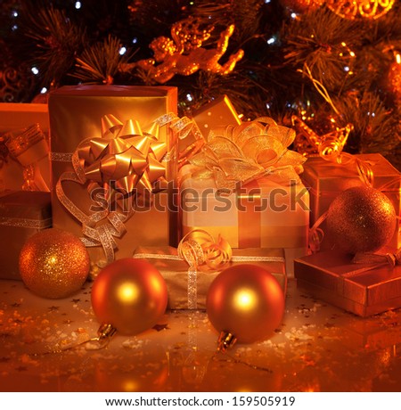 Picture of New Year presents under festive decorated fir tree, many different wrapping gift boxes, Christmastime house decoration, xmas surprise, golden Christmas tree toys, holiday concept