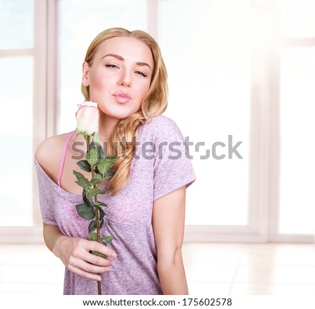 Sweet romantic girl with one rose at home, kissing lips, enjoying fresh gentle flowers, love in the air on Valentine day, affection concept