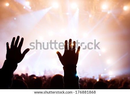 Musical concert, silhouette of man hands raised up, enjoying music in the club, luxury night performance, active lifestyle, having fun concept