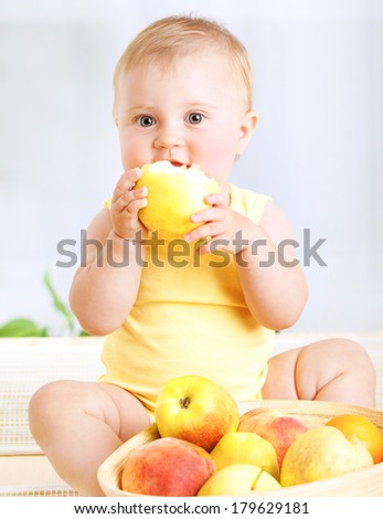 Happy little baby girl eating fresh tasty fruits for lunch, enjoying healthy food at home, organic nutrition for kids
