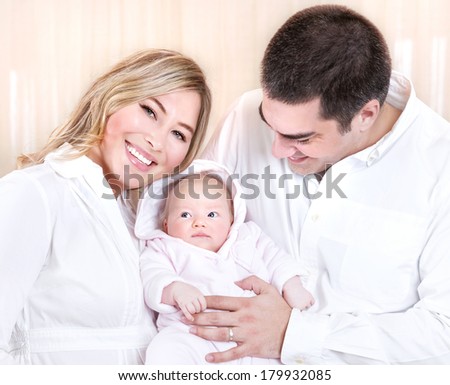 Beautiful happy mother and father carrying adorable sweet little daughter at home, conception of baby birth, new life, love concept
