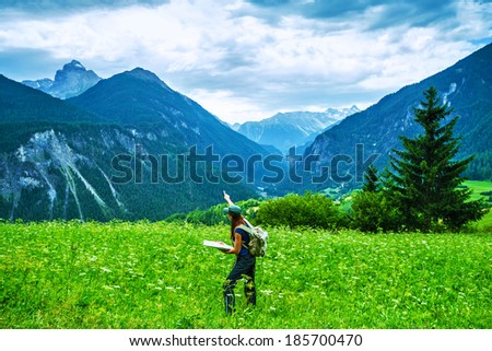 Happy traveler in the mountains, active woman searching right way on the map, travel to Alpine mountain, journey and adventure concept