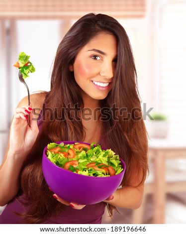 Sportive girl eating fresh vegetarian salad at home in the kitchen, loss weight, healthy nutrition, body care and beauty concept
