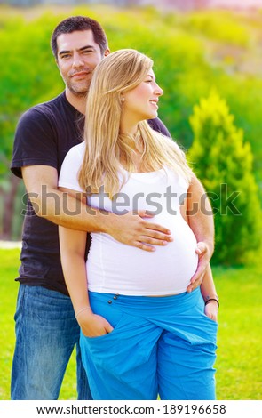 Young couple awaiting baby, husband take care about his pregnant wife, walking in spring park, loving family, new life concept