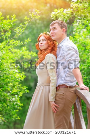 Just married, beautiful couple on wooden bridge in the park and looking up, dreaming about future, perfect wedding day, romantic and gentle relationship, love and happiness concept