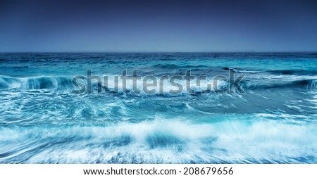 Dramatic stormy seascape, abstract natural background, overcast weather on the sea, big waves, slow motion sea waves