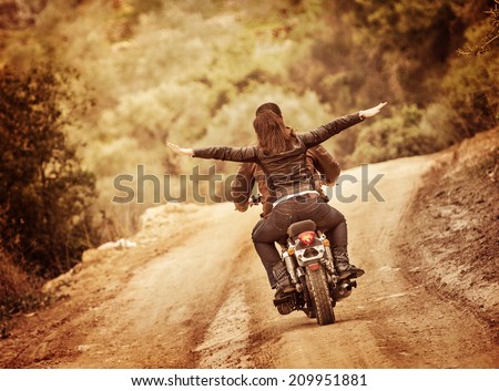 Sporty family traveling on motorbike, riding on motorcycle with raised up hands, active people, extreme sport, freedom concept