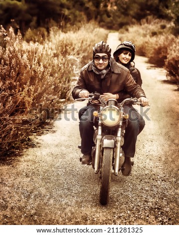 Vintage style image of two happy bikers riding on the road, active family enjoying journey on luxury extreme transport, freedom concept