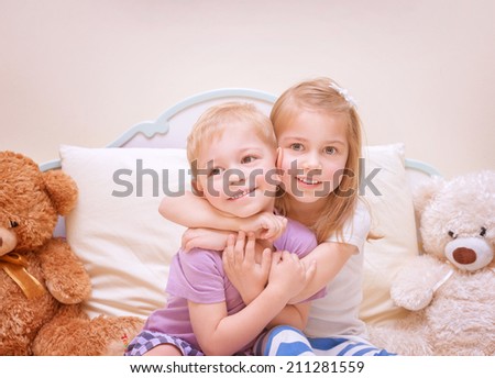 Portrait of two cute kids having fun at home, brother and sister playing in bedroom, healthy lifestyle, family love concept