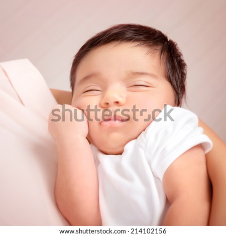 Closeup portrait of adorable Arabic child sleeping on mothers hands, little innocent baby, peace and harmony concept