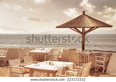 Luxury beach resort, cute white tables, chairs and umbrellas on sandy beach, cozy outdoors cafe, summer vacation concept