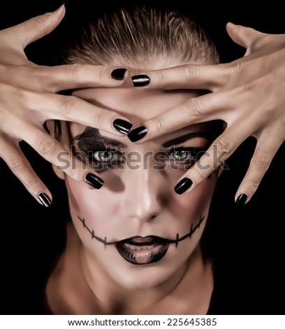 Closeup portrait of fashionable monster girl with hands near face isolated on black background, aggressive makeup for Halloween party