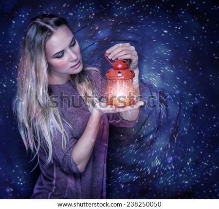 Portrait of beautiful woman with glowing lantern in hands over starry sky, magical Christmas night, fashion concept