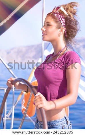 Portrait of beautiful woman sailing, sexy young captain standing behind helm of a sailboat and enjoying bright sun light, summer vacation concept