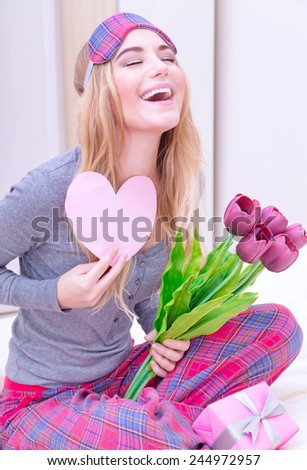Portrait of cute excited woman with romantic letter and laughing with closed eyes, awake and surprised of gentle romantic presents on Valentine\'s day