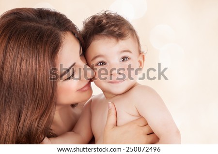Mother and baby boy closeup portrait, happy faces over beige background,  mom and kid having fun indoor, parents lifestyle, woman holding little child, healthy toddler and mommy, happiness concept
