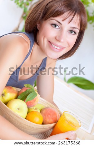 Portrait of beautiful woman eating fresh ripe fruits and drinking juice at home, loss weight, dieting and healthy nutrition concept