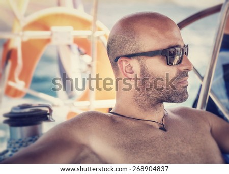 Closeup portrait of handsome shirtless man on sailboat, sexy sailor wearing sunglasses and enjoying sea trip, active lifestyle, summer travel and vacation concept