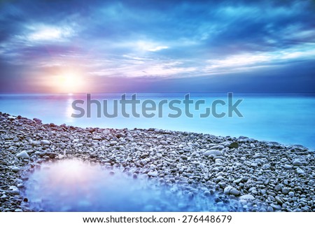 Beautiful seascape, amazing view of pebble coastline in mild sunset light, romantic evening on the beach, perfect place for summer holidays
