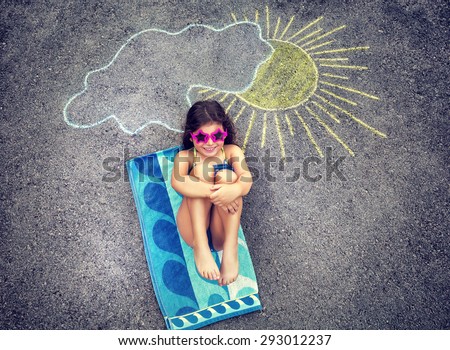 Cute creative little girl drawing on asphalt sun and tanning under it, wearing stylish swimsuit and sunglasses, summer holidays in the city