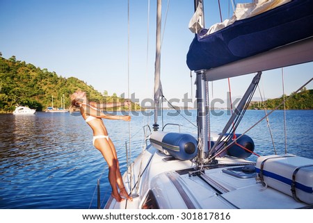 Joyful woman on sailboat, female with perfect body tanning and enjoying luxury summer vacation, active people lifestyle