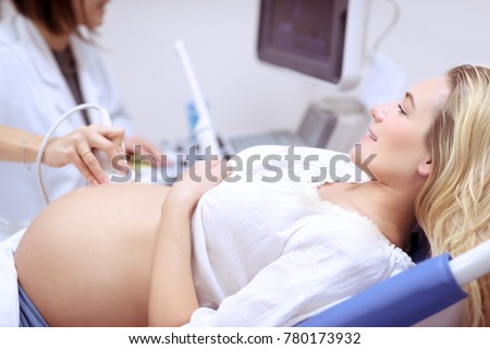 Happy pregnant female visiting women\'s doctor in the maternity center, doing ultrasound scan, worried about the health of the child, healthy motherhood concept
