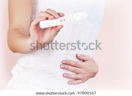 Positive pregnancy test result, closeup on pregnant belly, healthy mother touching tummy, female hand hold medical hormone test, isolated, new life and new family concept