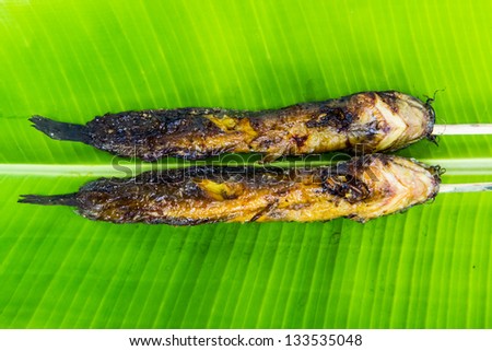 cat fish grill on green banana leaf