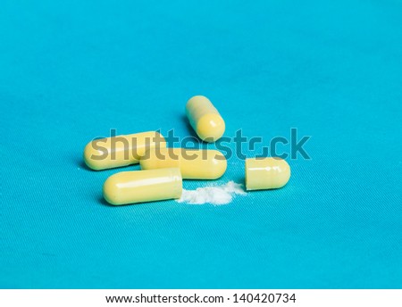 Medicine inside the capsules on blue background