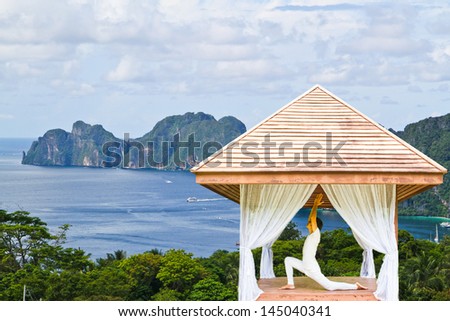 Model have yoga session on the mountain with ocean background.