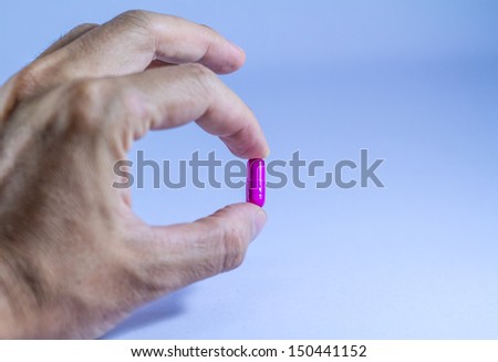 Purple medicine holding by hand .