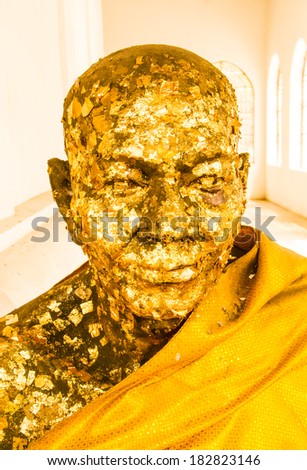 Figure of a monk wrap with gold leaf.