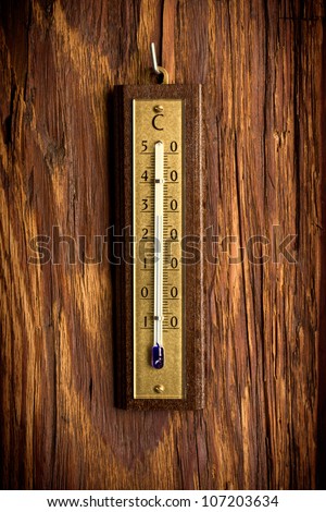vintage analog thermometer on old wooden background