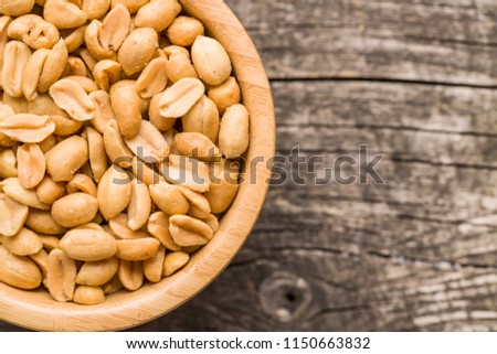 Salted roasted peanuts in bowl.