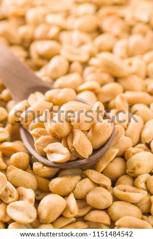 Salted roasted peanuts in scoop.