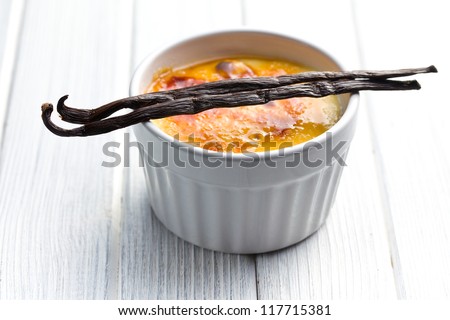 the creme brulee in ceramic bowl with vanilla pod