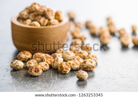 Tiger nuts. Tasty chufa nuts. Healthy superfood on old kitchen table.