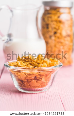 Breakfast cereals or cornflakes in bowl on pink background.