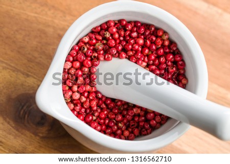 Dried pink peppercorn in mortar.