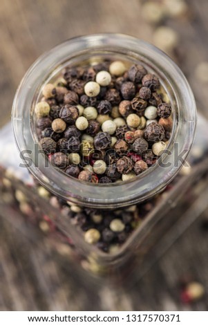 Different types of dried peppercorn in jar.