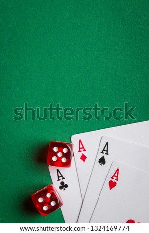 Poker cards and dice on green table.