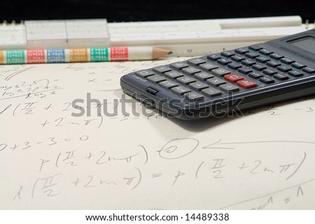 mathematical exercise with pencil ,calculator and sliding rule