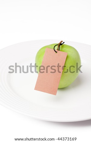 green apple with label on white plate