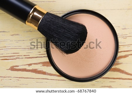 the makeup brush and cosmetic powder compact