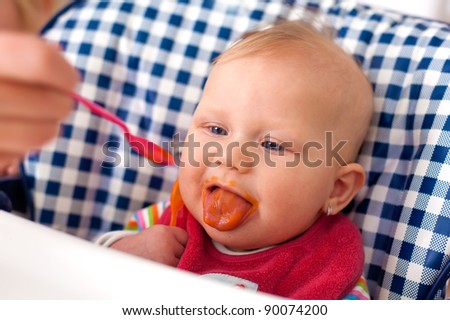 the photo shot of feeding baby food to baby