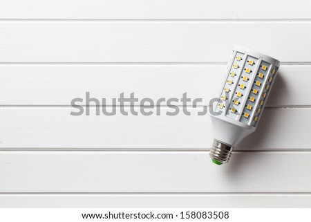 top view of LED light bulb on white wooden background